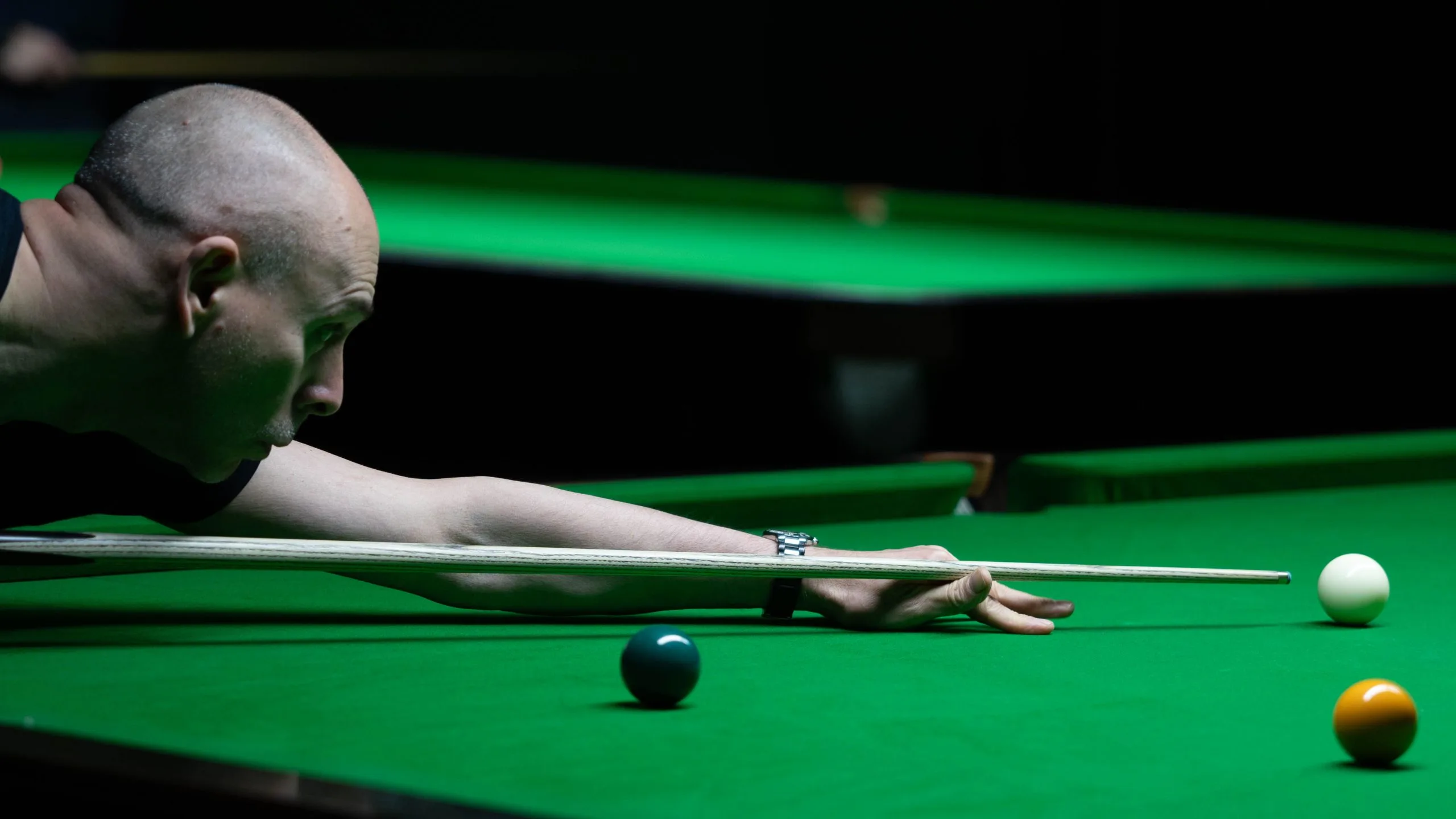 A player bending over a shot on a snooker table